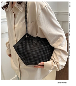 Détail du sac cabas noir orné de strass brillants et bandoulière en chaîne tressée