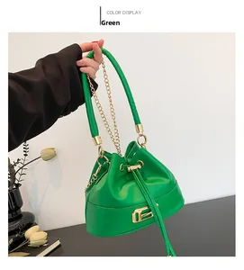 Detail of bright green leather bucket bag with gold hardware and drawstring closure
