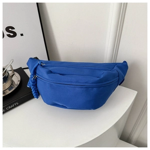 Close-up of royal blue nylon crossbody chest bag with double zippers and woven cord pullers