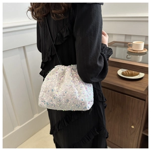 Détail du sac seau à paillettes avec fermeture à cordon et reflets colorés étincelants