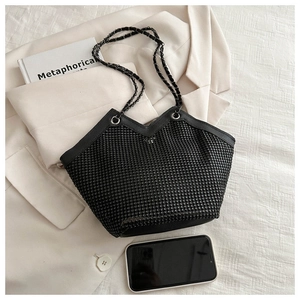 Détail d'un sac cabas noir avec strass scintillants, bandoulière chaîne et coupe en V