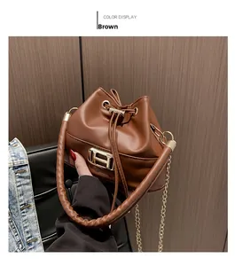 Detailed close-up of brown leather bucket bag with golden H clasp and woven handle