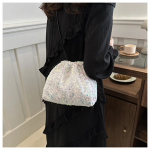 Détail du sac seau à paillettes irisées blanches avec fermeture à cordon et bandoulière