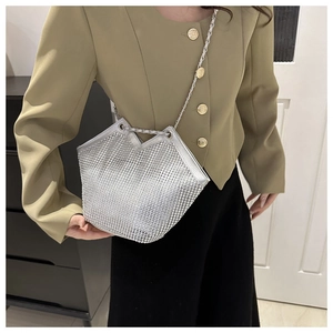 Détail du sac cabas en strass argenté avec bandoulière chaîne porté par un mannequin chic