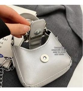 Detail view of the silver mini handbag showing the invisible magnetic buckle closure