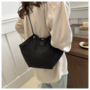 Détail du sac seau noir avec strass montrant la texture et la bandoulière sur l'épaule