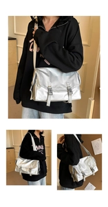 Detailed close-up showing the metallic silver finish and buckle closure of this messenger bag