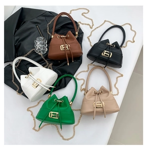 Detail view of five multi-color bucket bags with drawstrings and golden B-letter hardware