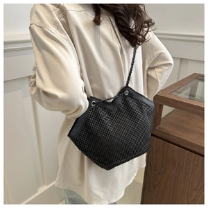 Sac fourre-tout noir à strass chic avec bandoulière en métal porté par un mannequin