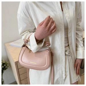 Detailed view of pale pink hobo bag with unique knotted handle and fashion branding