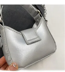 Close-up of a silver metallic mini flap bag with leather texture and chain strap