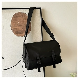 Detail view of durable black messenger bag with double plastic buckles and nylon texture