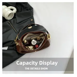 Detail view of the spacious inner compartment showing makeup items inside the shoulder bag