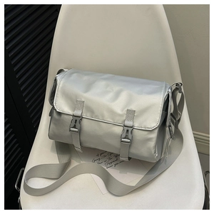 Detailed view of silver glossy messenger bag with buckle closure and wide strap