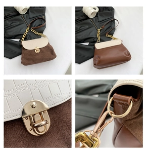 Detail of crocodile pattern flap and golden metal lock on a stylish contrast crossbody bag