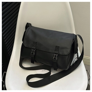 Detail of black matte nylon messenger bag with dual plastic buckles and adjustable strap