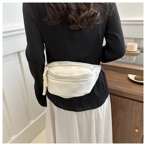 Detailed back view of a white minimalist waist bag with braided rope zipper on crossbody strap