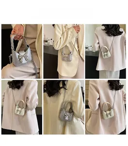 Detail view of mini bow purse showing silver and cream chain crossbody styling