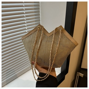 Détail d'un sac cabas doré en strass avec ouverture en V et bandoulière en métal doré
