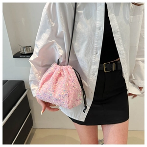 Détail de la texture des paillettes roses sur le sac seau avec fermeture à cordon