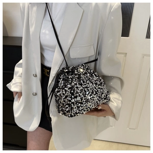 Détail d'un sac seau bicolore à paillettes avec cordon de serrage et bandoulière fine