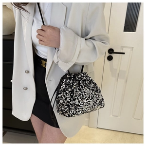 Détail du sac seau à paillettes avec cordon de serrage noir et blanc et bandoulière en cuir