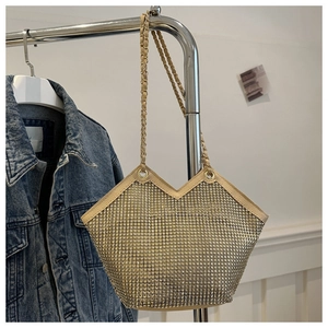 Détail d'un grand sac cabas doré en strass avec bandoulière chaîne tressée et fini chic