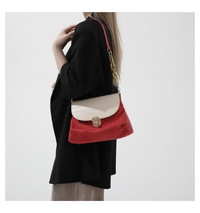 Detail view of red and white contrast shoulder bag with gold chain and crocodile texture