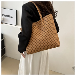 Detalle del bolso tote grande con estampado geométrico y remaches metálicos de protección