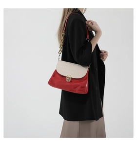 Detail of red and cream patchwork shoulder bag with gold clasp and chain strap