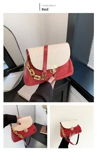 Detail view of red suede and cream crocodile pattern leather bag with gold chain strap