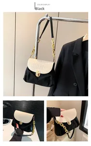 Detail view of stylish crossbody bag featuring gold clasp and mixed texture finish