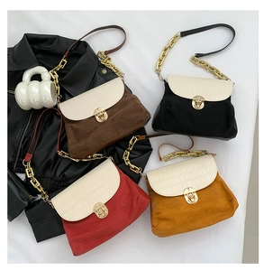 Close-up of stylish handbag collection with crocodile texture and gold chain straps
