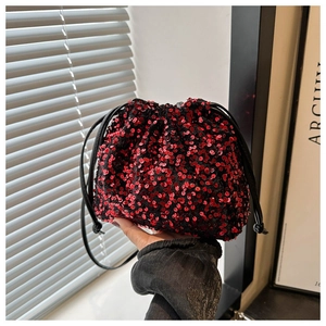 Détail du sac seau à paillettes rouges avec cordon noir pour soirée élégante