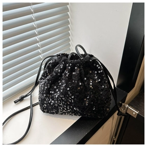 Détail des paillettes noires scintillantes et de la fermeture à cordon de ce sac seau