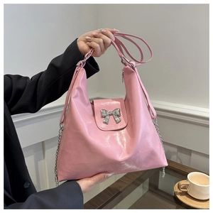 Détail du sac à épaule en cuir verni rose avec un nœud métallique argenté