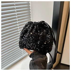 Détail du sac seau noir à paillettes avec cordon de serrage pour soirée chic