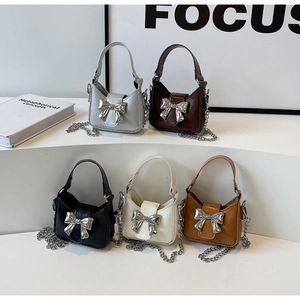 Detail showing five colors of mini bow handbags with metal chain straps and PU leather