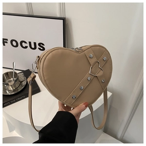 Details der beigen herzförmigen Tasche mit Nieten und dekorativer Herzmetallschnalle
