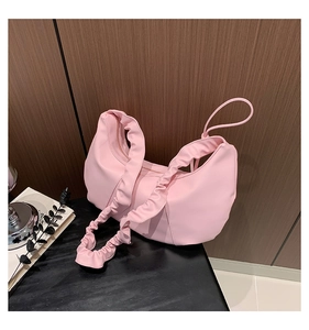 Close-up of pink ruched shoulder bag with soft matte leather texture and pleated details