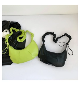 Close-up of pleated shoulder straps and smooth PU leather textures on hobo handbags