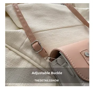 Detail of adjustable silver buckle and stitching on pink and silver shoulder bag