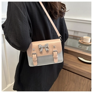 Pink and grey contrast crossbody bag with silver bow accent shown on a model