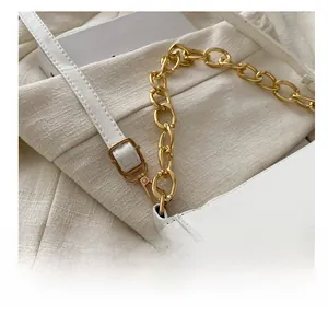 Detail of adjustable white leather strap and gold chain buckle on high-quality bag
