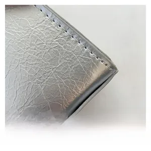 Gros plan détaillé sur la texture argentée métallique et les coutures de précision du sac