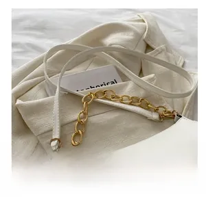 Detailed close-up of white leather shoulder bag with golden chain and sleek leather strap