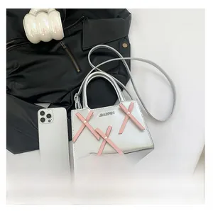 Vue à plat d'un sac à main argenté métallisé avec lacets roses et logo apparent