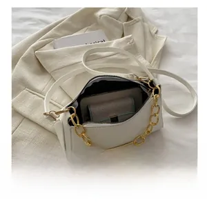 Detail view of white chain bag interior showing storage space for phone and wallet