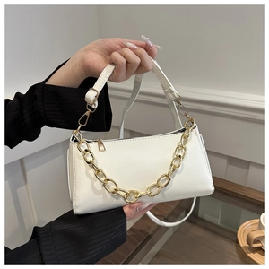 Detail of white PU leather baguette bag with thick gold chain and slim shoulder strap