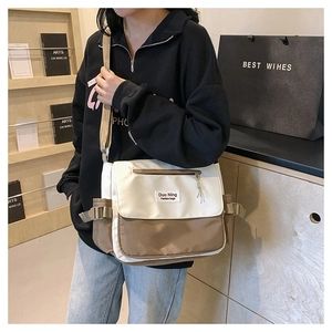 Detail view of the bicolor canvas messenger bag with adjustable strap for campus use